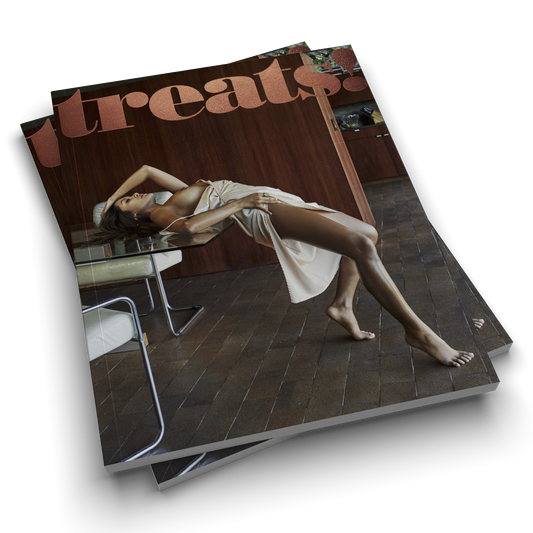 Magazine titled 'treats' with a woman lying on a table on the cover.