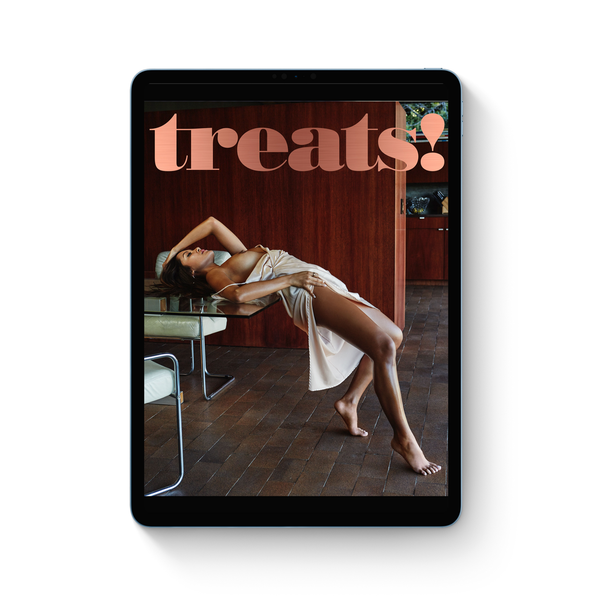 Tablet displaying a magazine cover with a woman lying on a chair and 'treats!' text.
